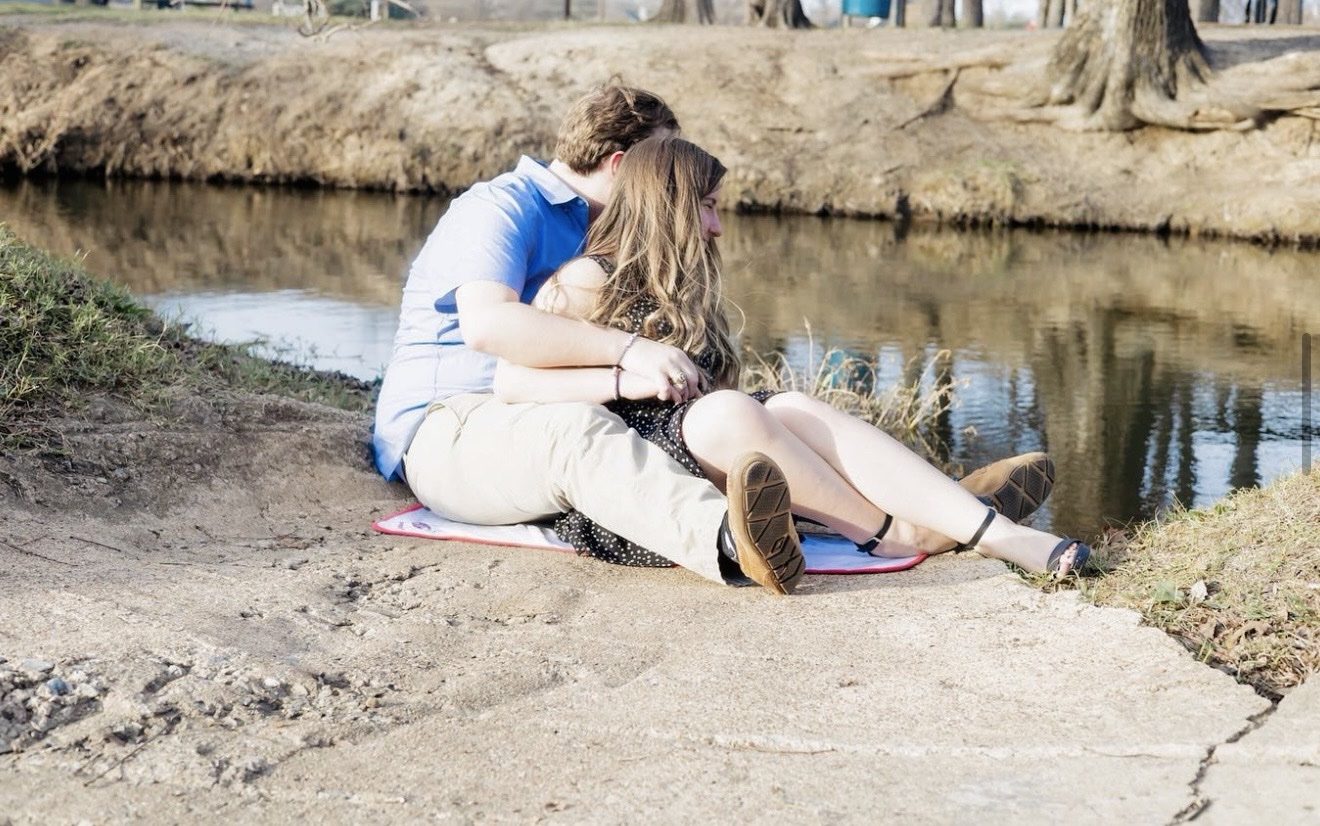 Couple sitting together beside the water, photographed by Kamar photography