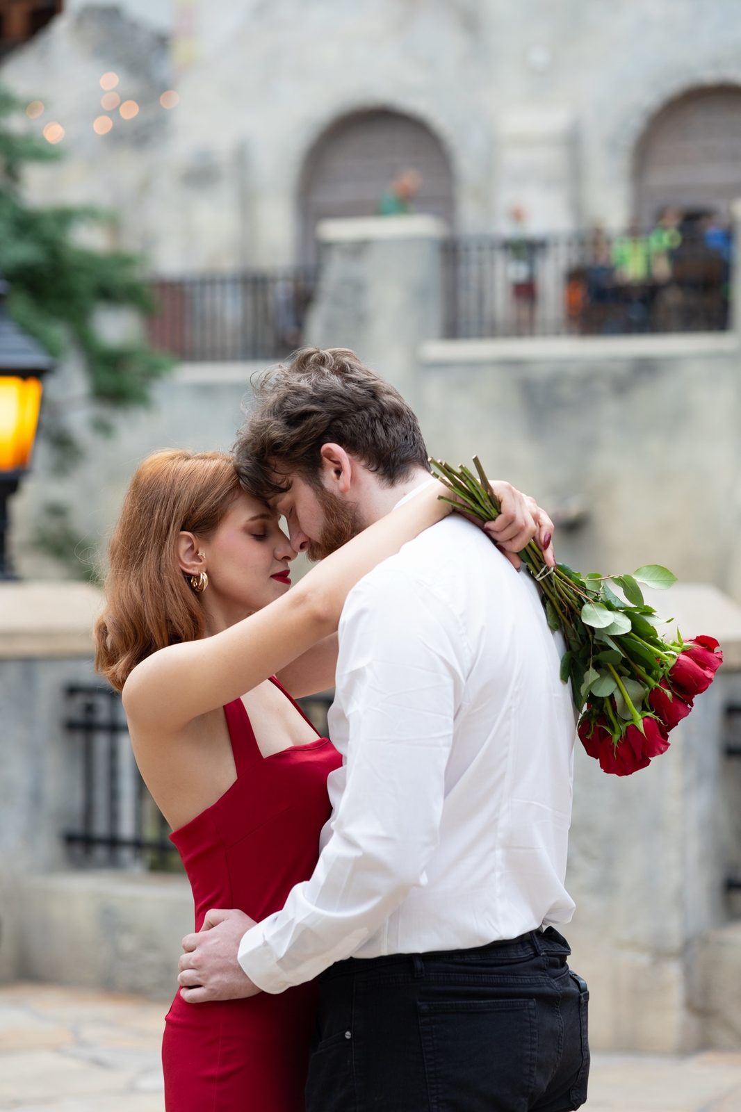 Couple embracing with a bouquet of red roses, photographed by Kamar photography