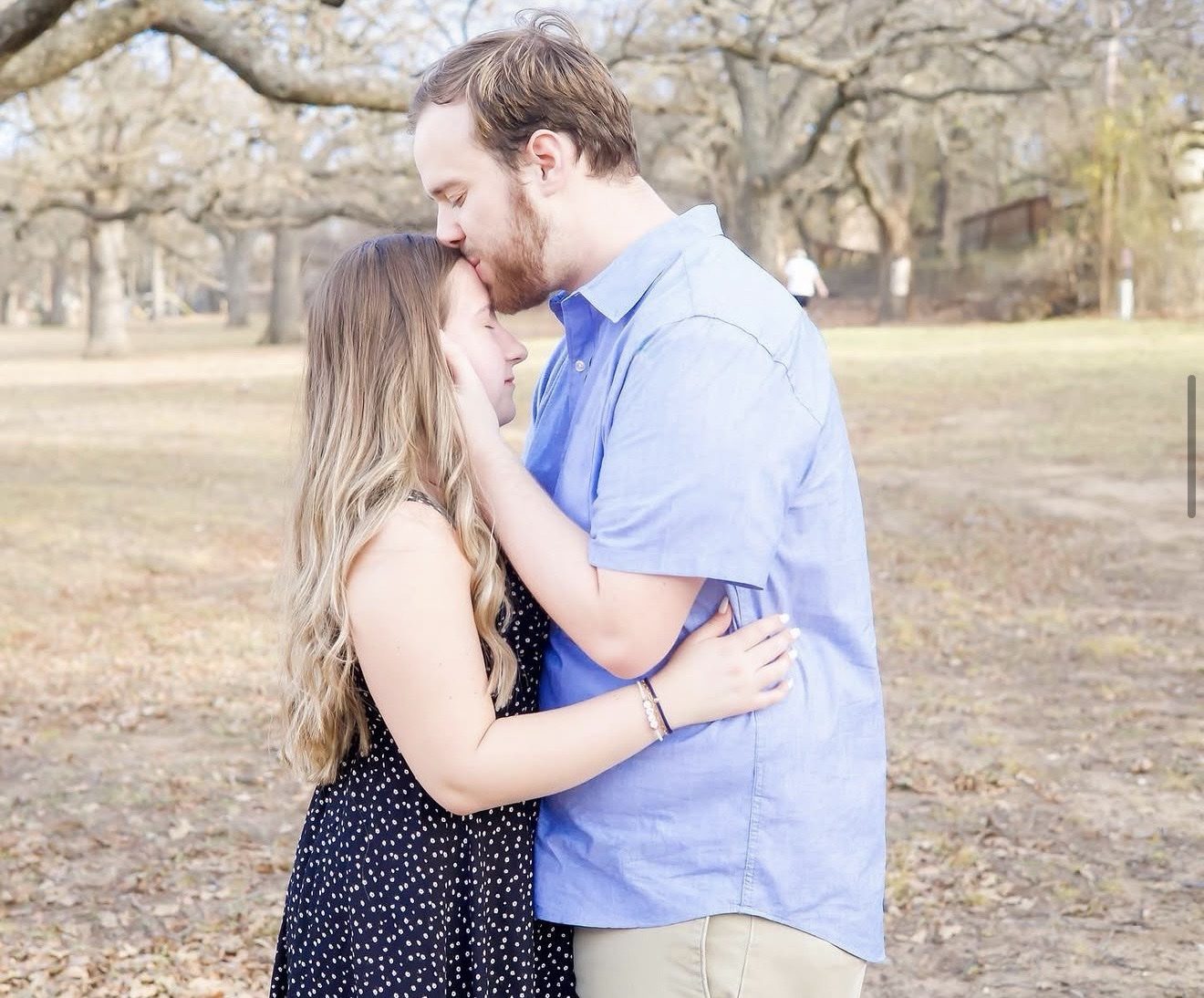 Couple sharing a forehead kiss outdoors, photographed by Kamar photography