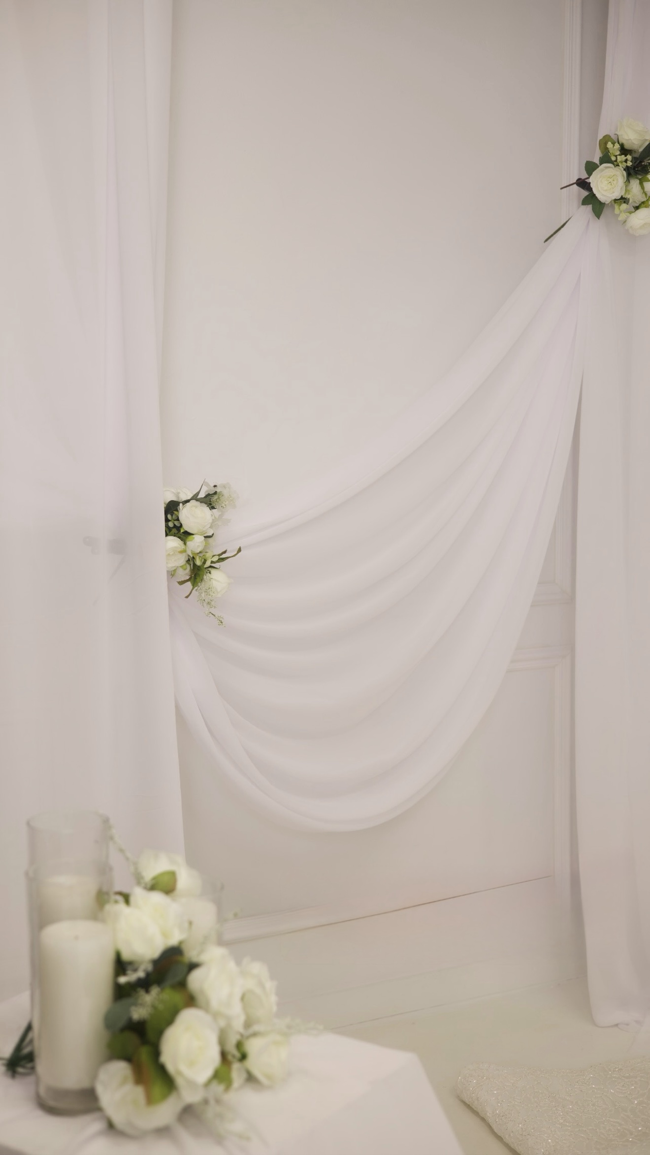 White draped backdrop with white roses and candles, nikkah decor photographed by Kamar photography