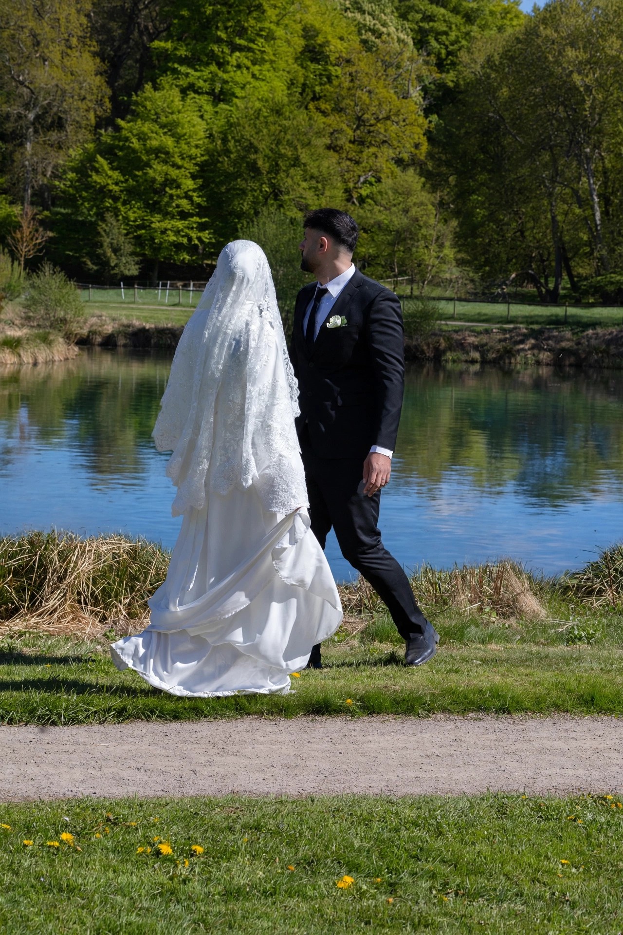 Couple walking together beside a lake, photographed by Kamar photography