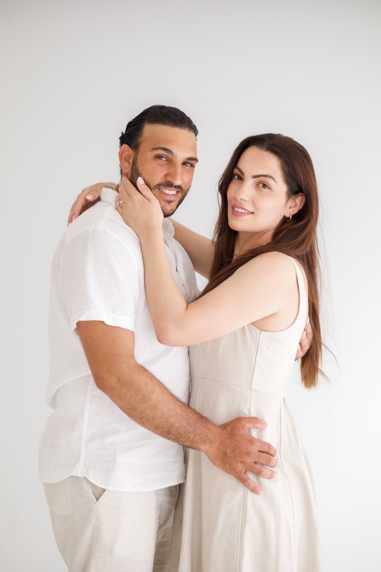 Couple embracing in a bright studio, photographed by Kamar photography
