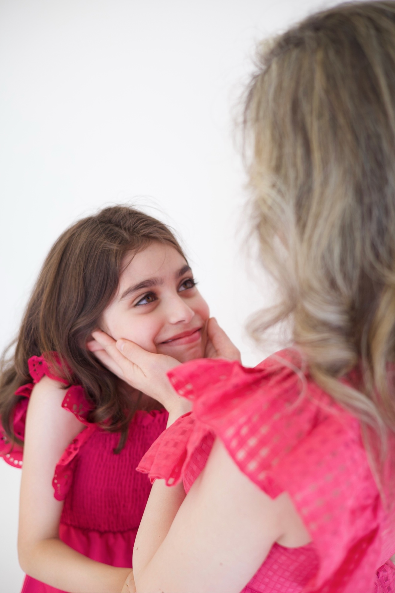 Mother gently holding her daughter’s face, photographed by Kamar photography