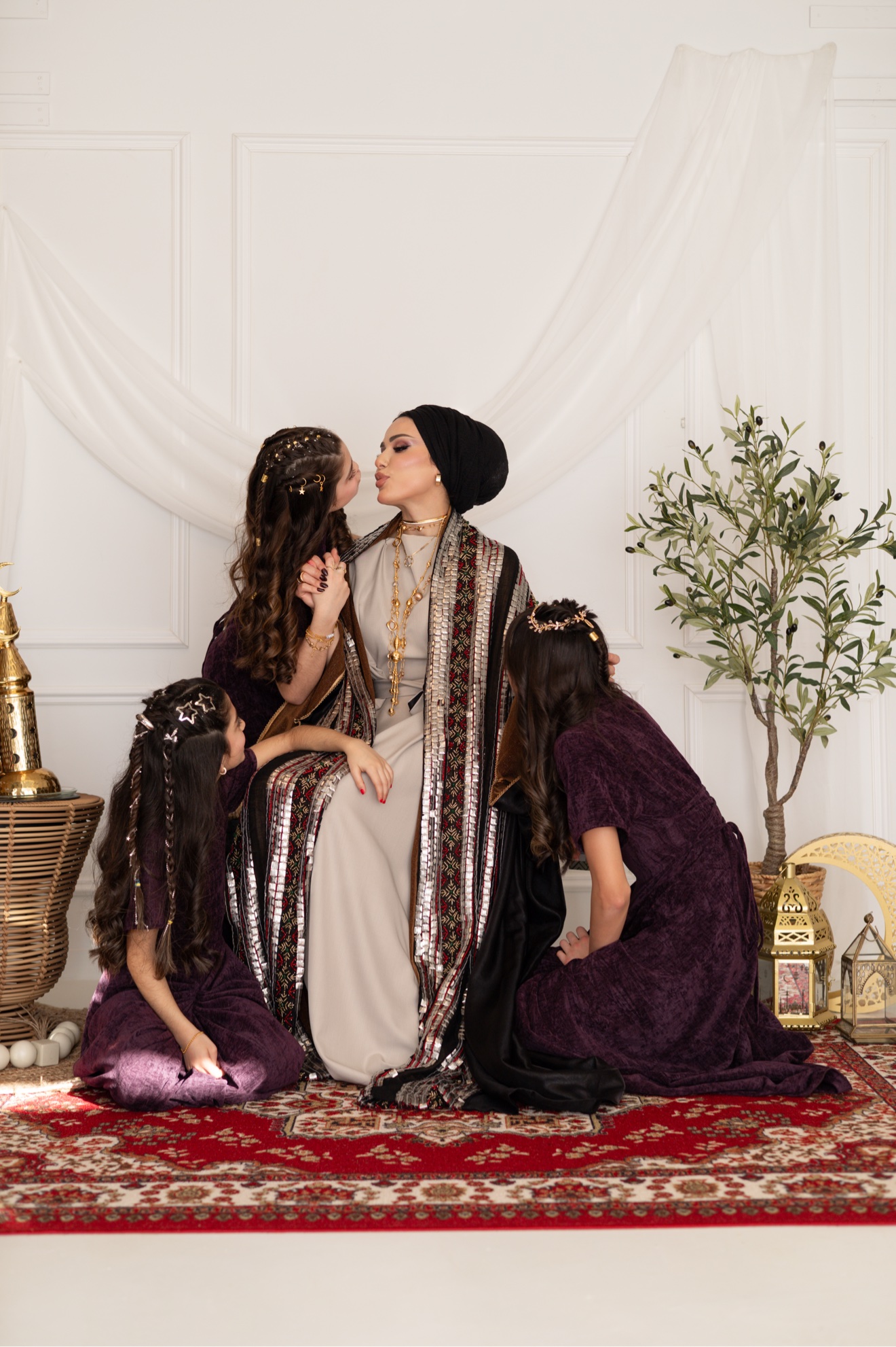 Mother in a black hijab with her three daughters in purple dresses in a Ramadan setting, photographed by Kamar photography