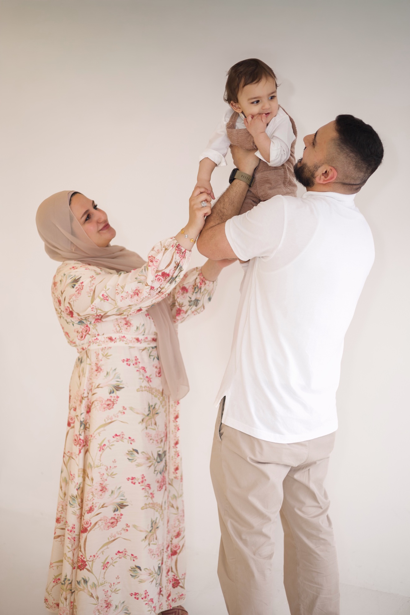 Parents lifting their baby together, photographed by Kamar photography