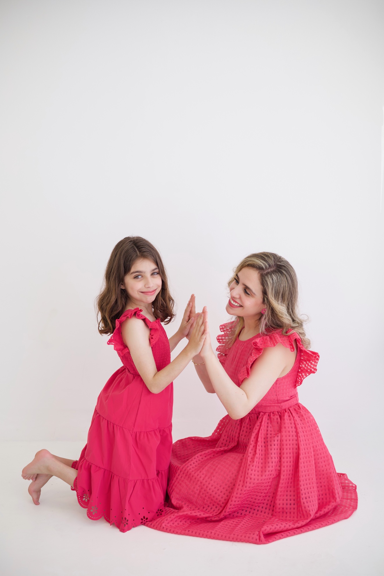Mother and daughter smiling as they high-five, photographed by Kamar photography